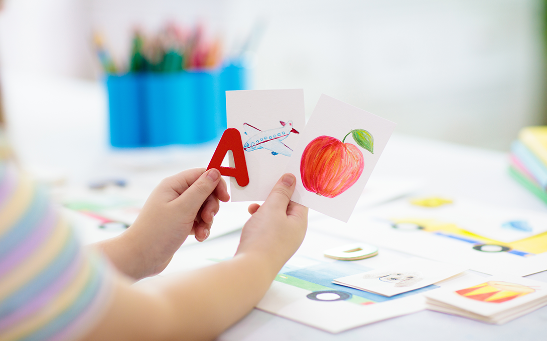 Student holding up several flashcards about language learning