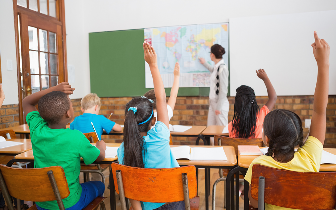 Students raising hands in classroom