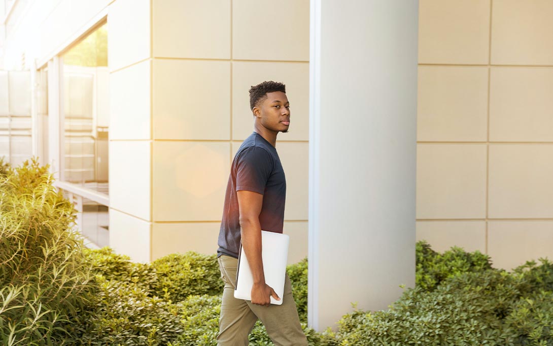 Student walking with laptop 