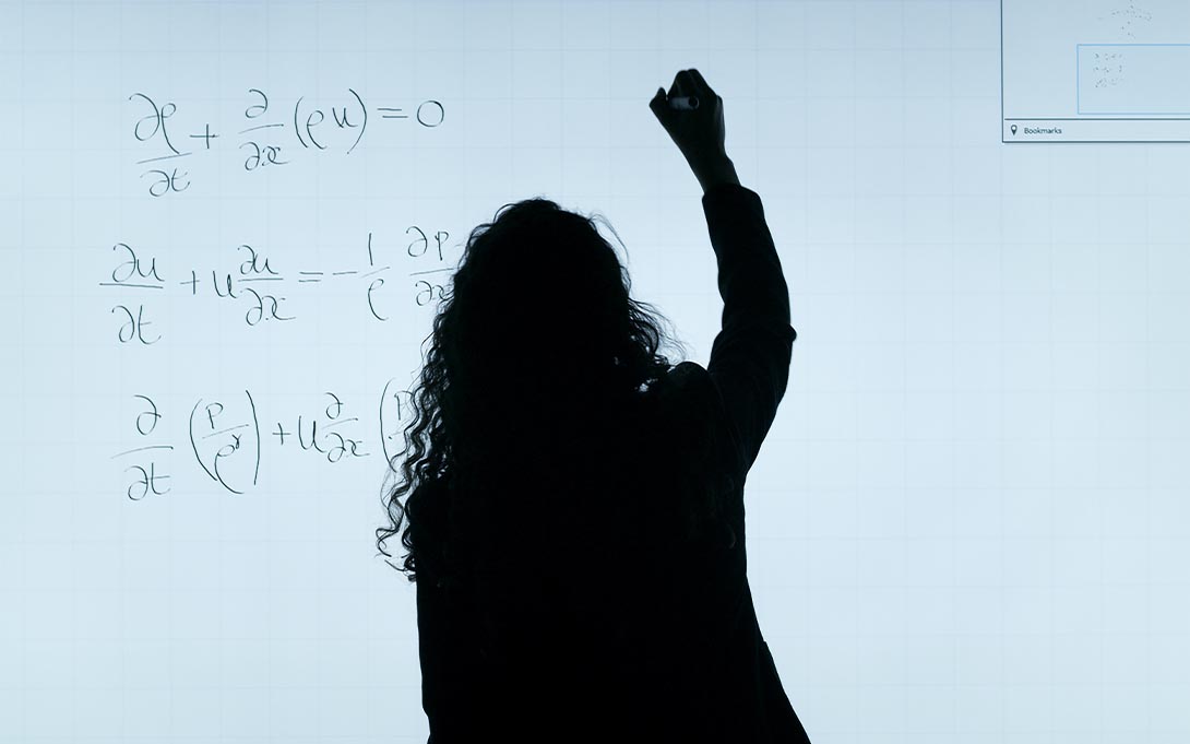 Teacher writing on a whiteboard