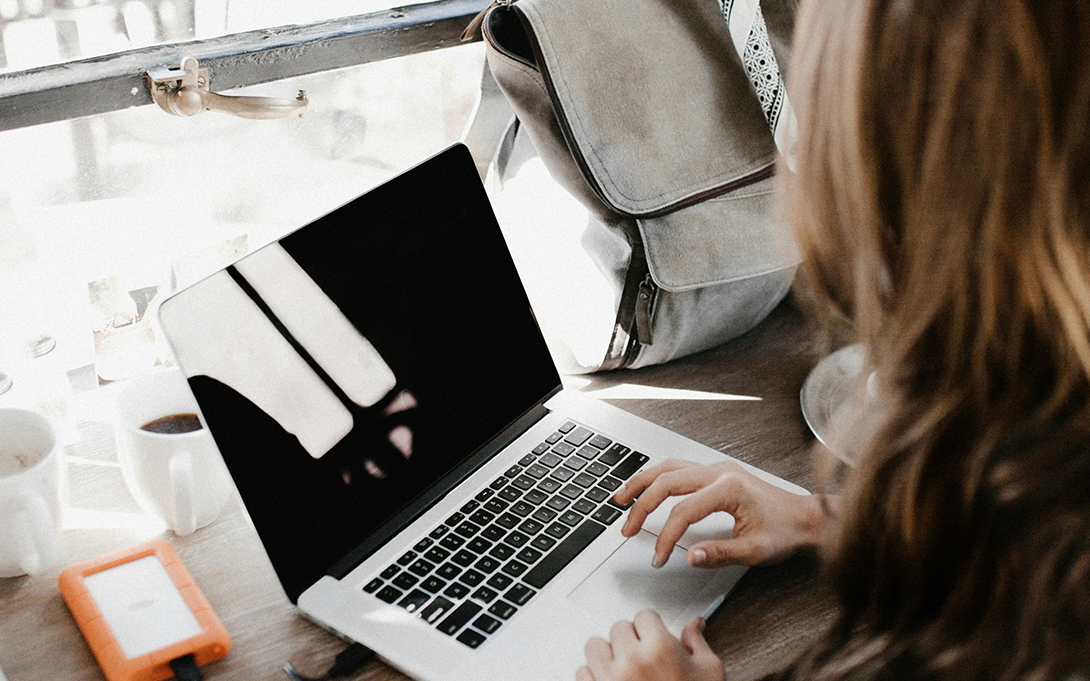 A young female checking information on a laptop.