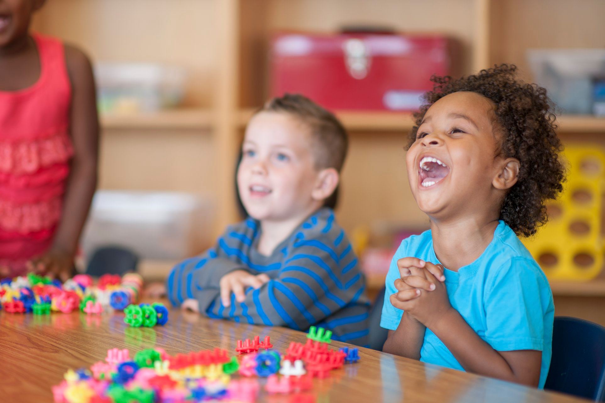 Young children smiling while playing with educational toys
