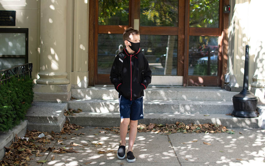 Elementary student wearing a mask outside of school
